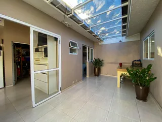 Sala de estar com teto de vidro que permite muita luz natural.