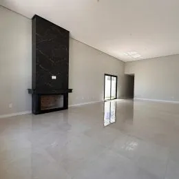 Ambiente interno amplo com lareira escura em um espaço minimalista.
