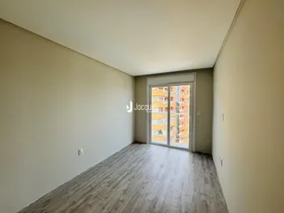 Ambiente interno de um imóvel com piso de madeira e paredes claras.