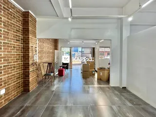 Hall de entrada com paredes de tijolo aparente e piso de cerâmica.