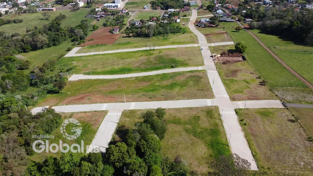 Vista aérea de um terreno aberto com vegetação e estradas de terra.