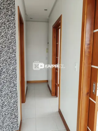 Corredor interno com paredes brancas e piso de cerâmica claro.