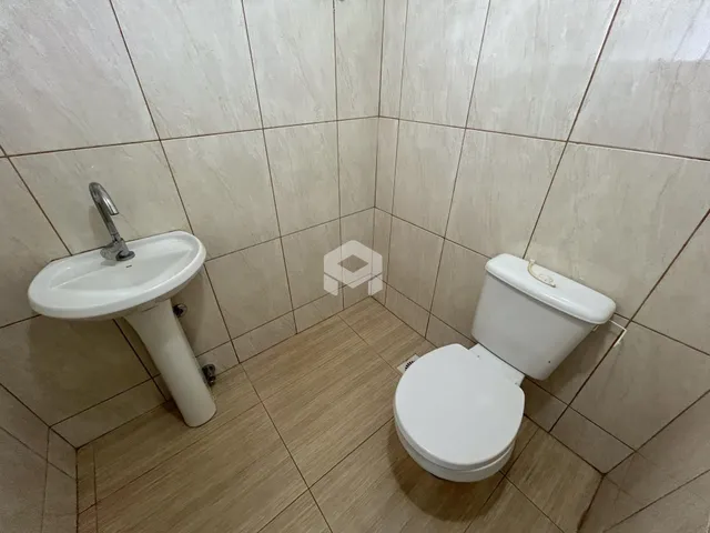 Foto de um banheiro com pia e vaso sanitário em cerâmica.