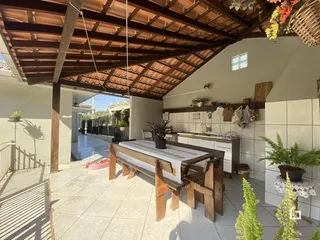 Área externa coberta com piso de cerâmica e estrutura de madeira.