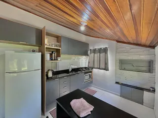 Imagem de uma cozinha com armários modernos e teto de madeira no Brasil.