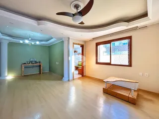 Sala de estar ampla com piso de madeira clara e paredes verdes.