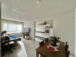 Sala de estar com janela e mesa de jantar em imóvel no Brasil.