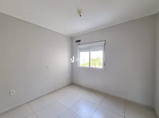 Ambiente interno de uma sala com paredes brancas e piso de cerâmica.