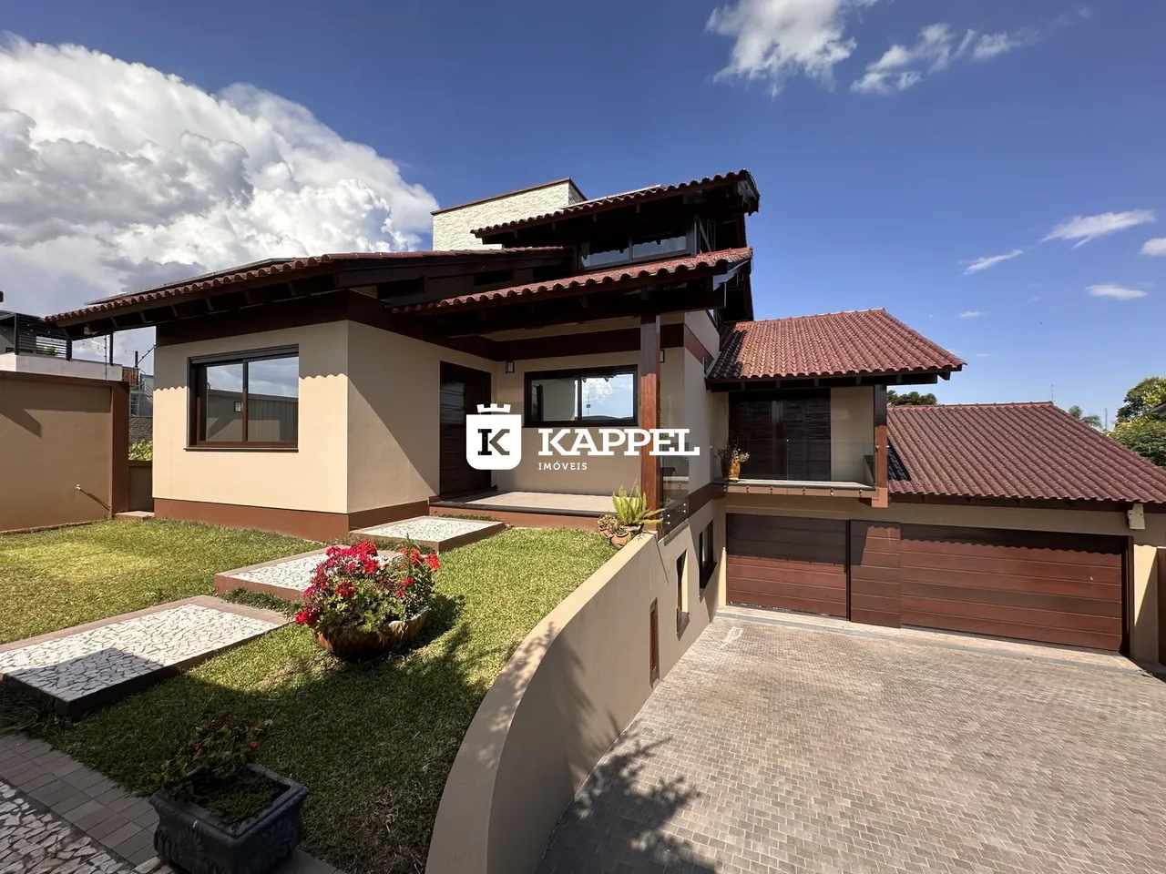 Fachada de uma casa residencial em Lajeado, Brasil, com jardim frontal e garagem.