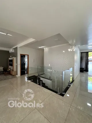 Sala de estar com piso de cerâmica e divisória de vidro.