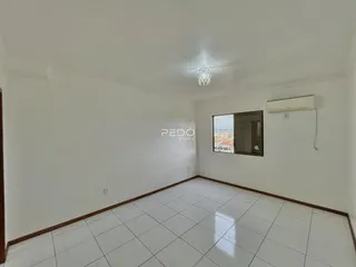 Ambiente interno de uma sala com piso de cerâmica e janela.
