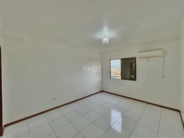 Ambiente interno de uma sala com piso de cerâmica e janela.