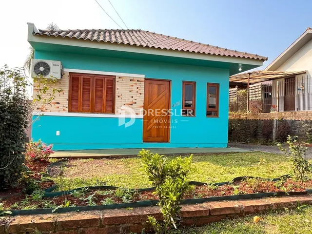 Fachada de uma casa azul em Lajeado, Brasil, com telhado de telhas.