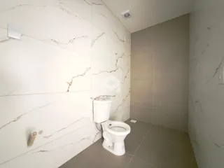 Interior de um banheiro com revestimento de mármore branco.