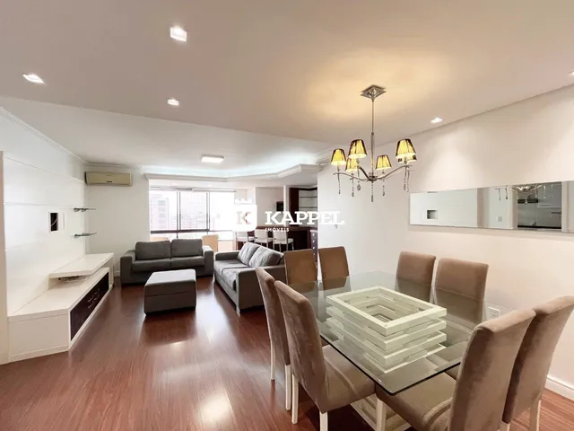 Sala de estar com sofá e mesa de jantar em um apartamento moderno.