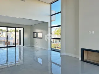 Sala de estar com piso de concreto polido e grandes janelas.
