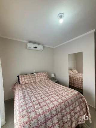 Quarto com cama e espelho em ambiente interno.