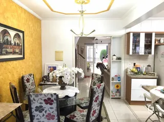 Sala de estar com paredes amarelas e piso de madeira.