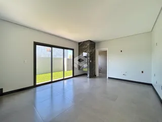 Vista interna de um ambiente amplo com porta de vidro que dá para o exterior.