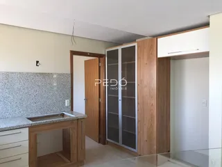 Uma cozinha com armários de madeira e bancada.