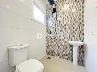 Foto de um banheiro com revestimento de parede em tons terrosos.