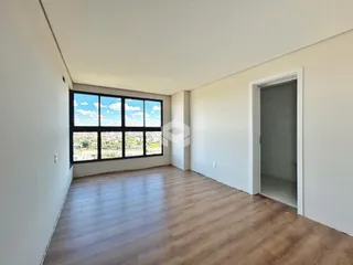 Interior de um cômodo com grande janela de vista para a cidade.