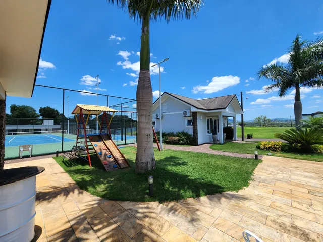Vista externa de uma casa com área verde e quadra esportiva em Lajeado, Brasil.