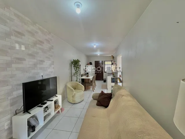Uma sala de estar com sofá e televisão é visível na propriedade.