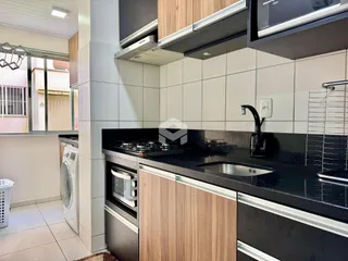 Cozinha moderna com armários de madeira e bancada escura.