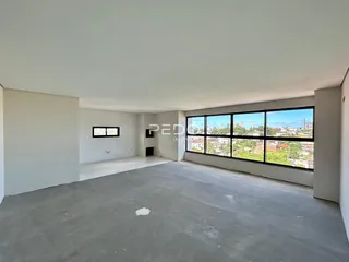 Um cômodo interno vazio com paredes brancas e piso de concreto.