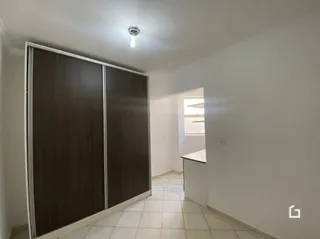 Corredor interno com piso de cerâmica e paredes brancas.