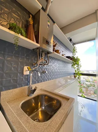 Vista de uma bancada de cozinha com pia e revestimento azul na Lajeado.