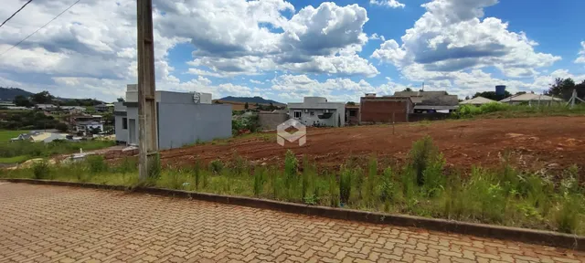 Vista externa de um terreno com construções ao fundo.