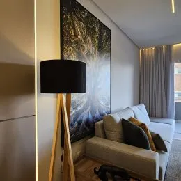 Sala de estar com sofá e arte escura na parede.