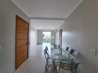 Hall de entrada com porta de madeira e piso cerâmico claro.