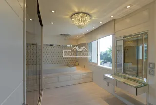 Quarto com cama e divisória de vidro em um imóvel no Brasil.