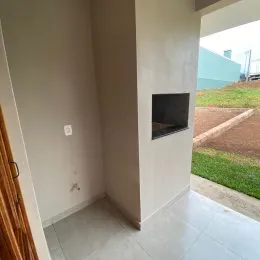 Hall de entrada interno com paredes brancas e piso claro.