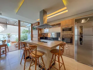 Vista da cozinha moderna com ilha e armários de madeira.