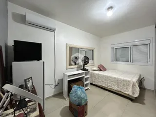Quarto interno com cama e janela em uma residência.