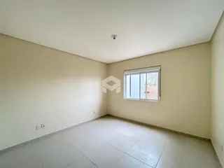 Ambiente interno de uma sala com piso de cerâmica e parede clara.