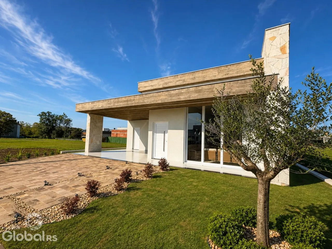 Fachada moderna de uma residência em Lajeado, Brasil, com área externa pavimentada e gramado.