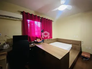 Quarto com cama e janela decorada com cortinas vermelhas.