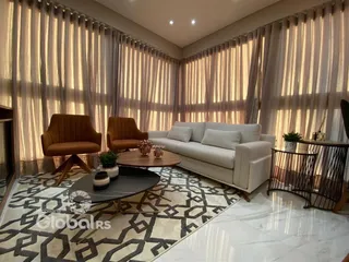 Sala de estar com sofá e cortinas claras em um imóvel no Brasil.