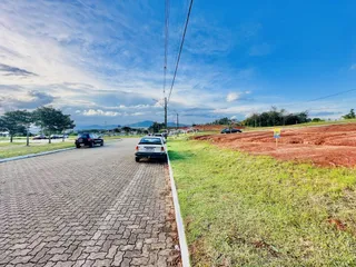 Vista da rua com gramado e campo aberto ao lado da propriedade.