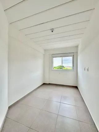 Hall de corredor interno com piso de cerâmica e teto branco.
