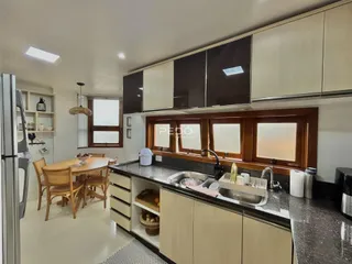 Vista interna de uma cozinha com armários de madeira e bancada em Lajeado.