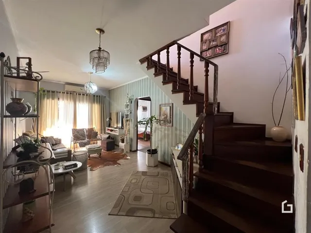 Sala de estar com escadaria e decoração interna.