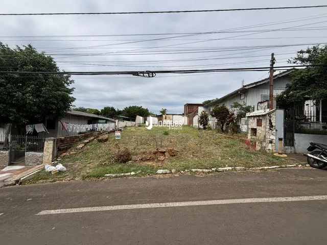 Vista externa de uma propriedade com terreno gramado e estrada no primeiro plano.