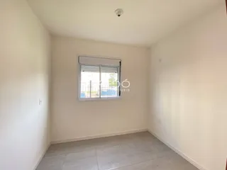 Ambiente interno de uma sala com piso de cerâmica e janela.