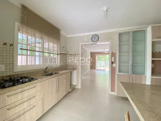 Vista da cozinha com armários e piso cerâmico.